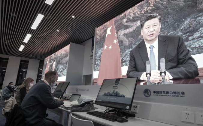 Журналисты сидят рядом с экранами, на которых видно, как лидер Китая Си Цзиньпин произносит речь 4 ноября 2020 г. STR / AFP via Getty Images | Epoch Times Россия