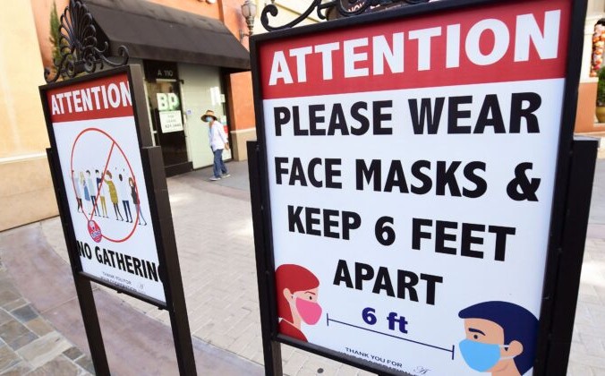 Знаки, напоминающие людям о социальной дистанции и ношении масок для лица, в торговом центре в Монтерей-парке, штат Калифорния, 14 июня 2021 г. FREDERIC J. BROWN/AFP via Getty Images | Epoch Times Россия
