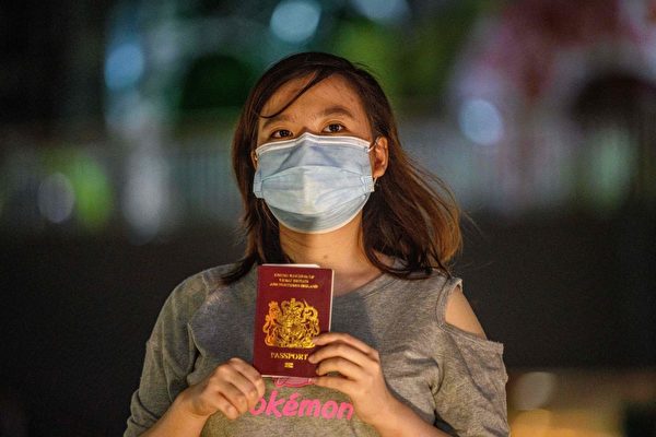 Гражданка Гонконга держит британский паспорт BNO в июне 2020 года. (ANTHONY WALLACE/AFP через Getty Images) | Epoch Times Россия