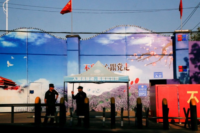 Охранники стоят у ворот центра «профессионального обучения» в округе Хуочэн Синьцзян-Уйгурского автономного района Китая, 3 сентября 2018 г. (Reuters/Thomas Peter/File Photo) | Epoch Times Россия