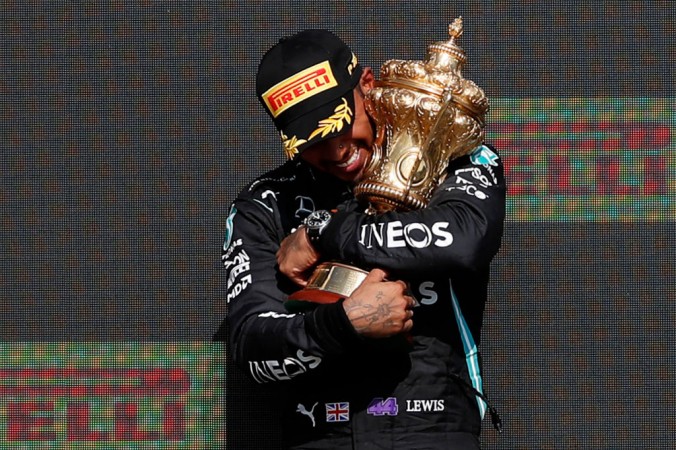 Британский гонщик-победитель «Мерседес» Льюис Хэмилтон держит трофей на подиуме после автогонки Гран-при Великобритании Формулы-1 на автодроме в Сильверстоуне, центральная Англия, 18 июля 2021 г. ADRIAN DENNIS/AFP via Getty Images | Epoch Times Россия