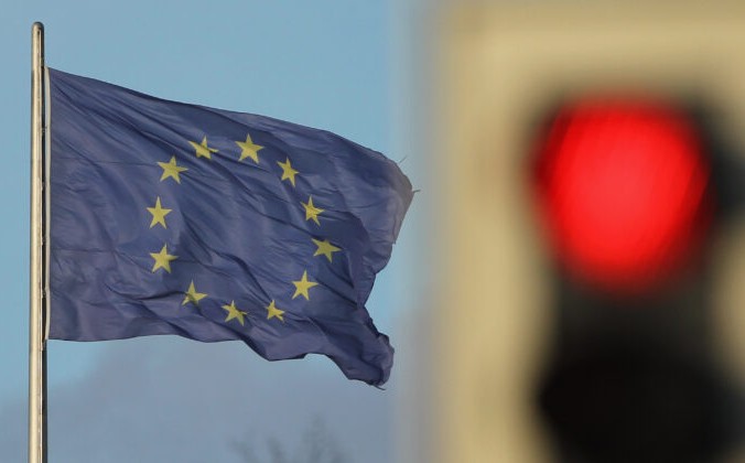 Флаг Евросоза развевается на ветру возле красного светофора в Берлине, Германия, 30 ноября 2011 г. Фото: Шон Гэллап / Getty Images | Epoch Times Россия