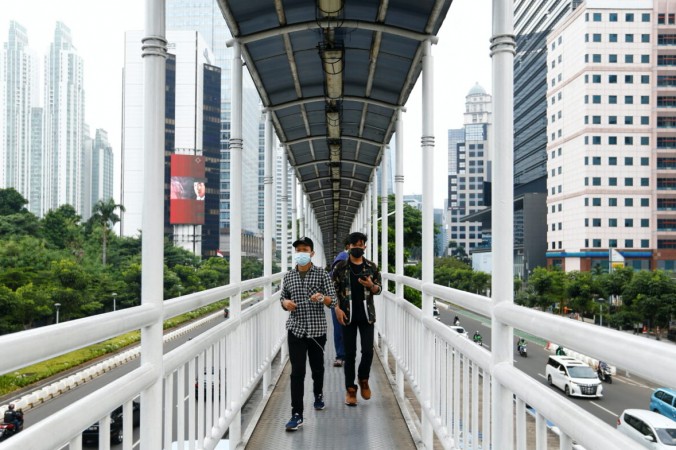 Люди в защитных масках идут по мосту в Джакарте, Индонезия, 17 июня 2021 г. (Ajeng Dinar Ulfiana / Reuters) | Epoch Times Россия
