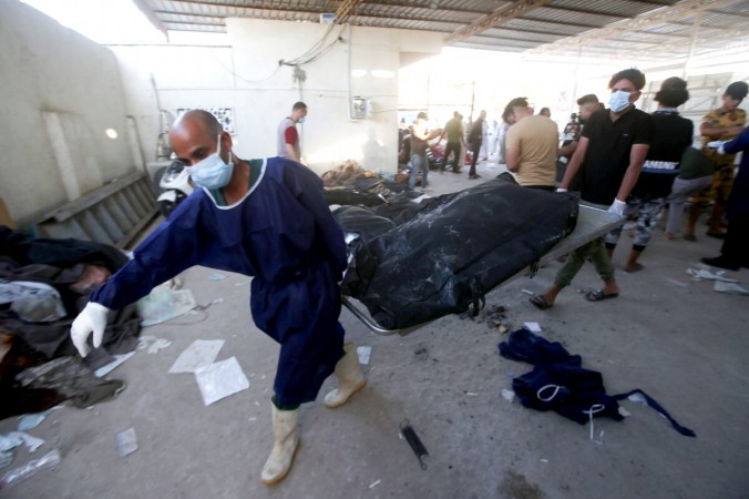 Мужчины несут носилки с останками жертв после пожара в больнице аль-Хуссейна в Насирии, Ирак, 13 июля 2021 г. (Essam al-Sudani / Reuters) | Epoch Times Россия