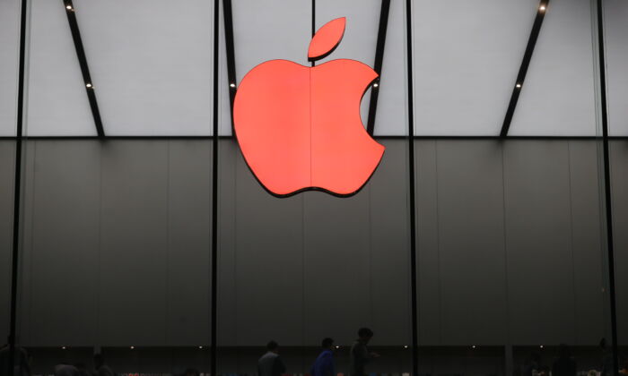 Красный логотип Apple можно увидеть в магазине Apple во Всемирный день борьбы со СПИДом 1 декабря 2015 года в Ханчжоу, провинция Чжэцзян, Китай. (Сюй Канпин / VCG / Getty Images) | Epoch Times Россия