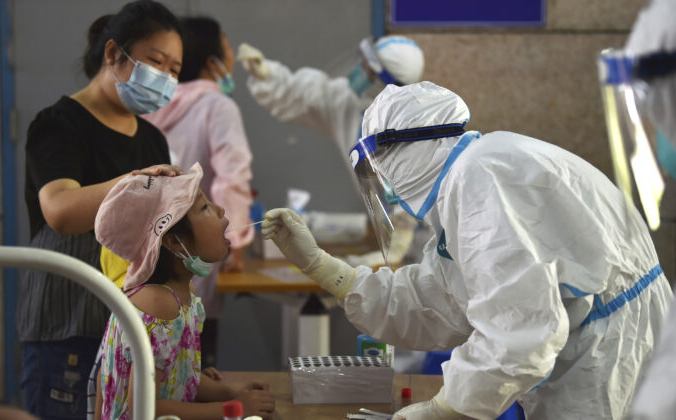 Медсестра берёт мазок из горла во время очередного тестирования на COVID-19 в Нанкине, провинция Цзянсу, восточный Китай, 2 августа 2021 г. Chinatopix / Via AP | Epoch Times Россия