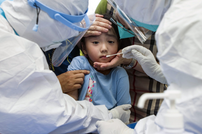 Ребёнок реагирует на мазок из горла во время массового тестирования на COVID-19 в Ухане, провинция Хубэй в центральном Китае, 3 августа 2021 г. (Chinatopix / via AP) | Epoch Times Россия