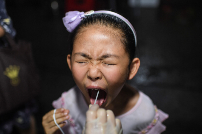 Ребёнок проходит тест на COVID-19 в жилом районе в Ухане, провинция Хубэй, 11 августа 2021 г. (STR/AFP via Getty Images) | Epoch Times Россия