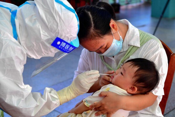 13 сентября 2021 года ребёнок проходит тест на коронавирус Covid-19 в городе Путянь в восточной провинции Китая Фуцзянь. (- / CNS / AFP via Getty Images)