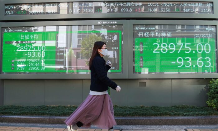 Женщина проходит мимо электронной биржи ценных бумаг в Токио, Япония, 18 октября 2021 г. (Koji Sasahara/AP Photo) | Epoch Times Россия