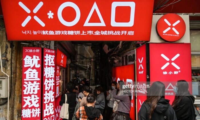 Покупатели выстраиваются в очередь в небольшом магазине, чтобы купить догоны, представленные в игре Squid Game, в Шанхае, Китай, 12 октября 2021 г. Hector Retamal/AFP via Getty Images | Epoch Times Россия