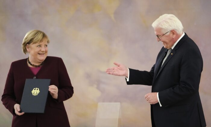 Канцлер Германии Ангела Меркель (слева) получает свидетельство об увольнении от президента Германии Франка-Вальтера Штайнмайера в Берлине, Германия, 26 октября 2021 г. Markus Schreiber/AP Photo | Epoch Times Россия