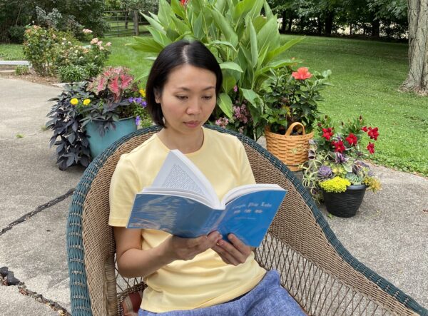 Лэ Ми Хань читает книгу, в которой изложено главное учение Фалуньгун. С любезного разрешения Лэ Ми Хань