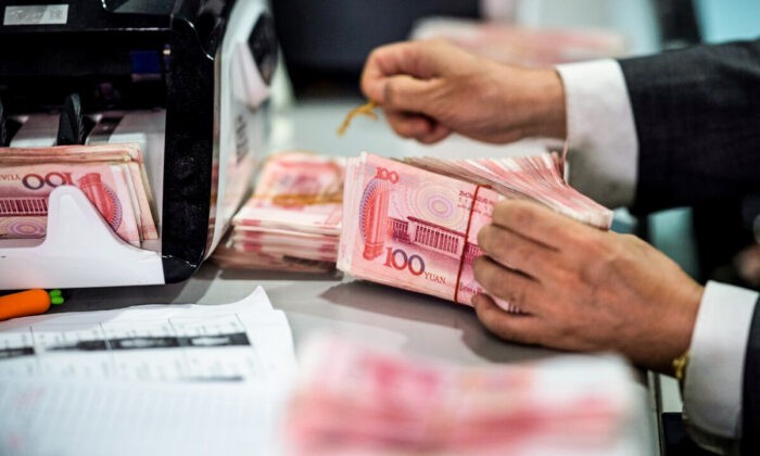 Сотрудник банка отсчитывает банкноты 100 юаней в банке в Шанхае 8 августа 2018 г. (Johannes Eisele / AFP via Getty Images) | Epoch Times Россия