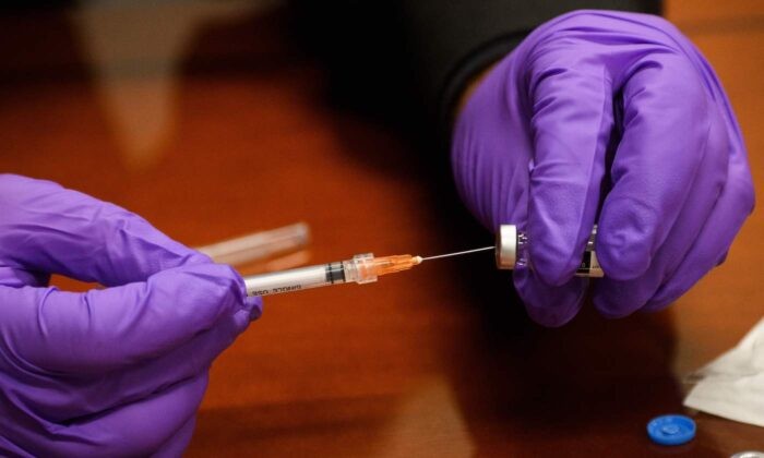 Медик заполняет ампулу с дозой вакцины Covid-19. (Patrick T. Fallon/AFP via Getty Images) | Epoch Times Россия