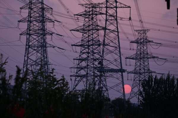За линией электропередач садится солнце, Пекин, 28 сентября 2021 г. (Leo Ramirez/AFP via Getty Images)