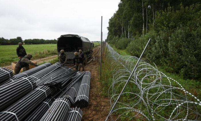 Польские солдаты выгружают материалы для строительства проволочного забора на восточной границе Польши с Беларусью 26 августа 20221 г. (Jaap Arriens/AFP via Getty Images)  | Epoch Times Россия