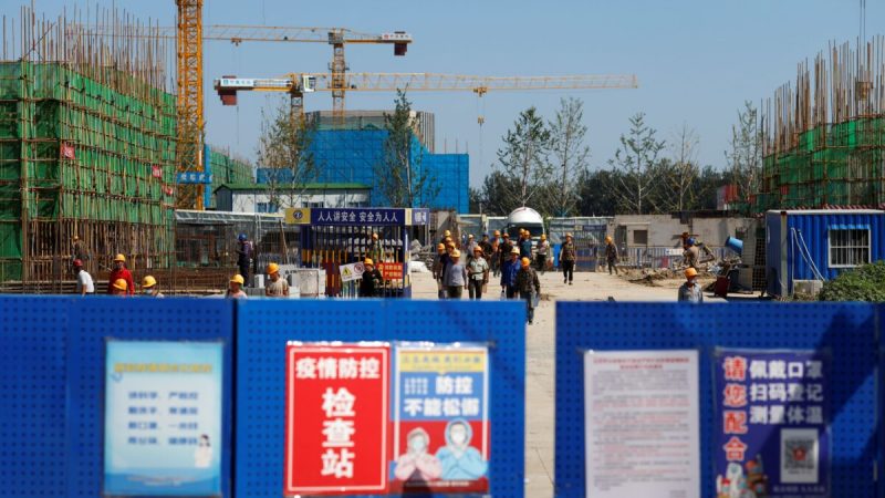 Рабочие заходят на строительную площадку одного из объектов Evergrande Group в Пекине. 22 сентября 2021 года. (Carlos Garcia Rawlins/Reuters) | Epoch Times Россия