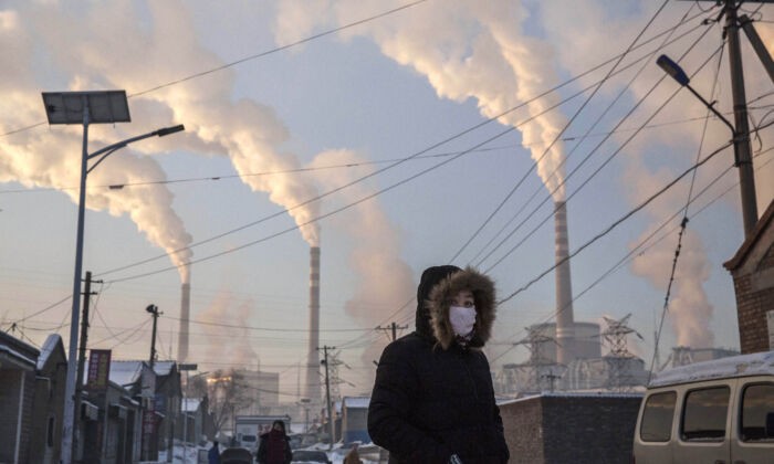Китаянка в маске идёт неподалёку от угольной электростанции в Шаньси, Китай, 26 ноября 2015 г. Kevin Frayer / Getty Images | Epoch Times Россия
