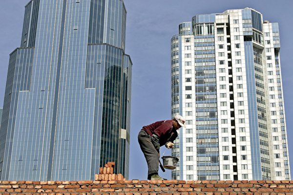 Репрессивные меры коммунистического правительства в отношении бизнеса и магнатов изменили рейтинг самых богатых людей Китая. На снимке: строитель кладёт кирпичи возле высотных домов в Шанхае, 31 марта 2005 г. AFP PHOTO / LIU Jin | Epoch Times Россия