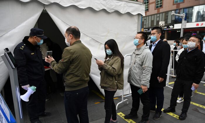 Люди выстраиваются в очередь, чтобы сделать ревакцинацию от COVID-19 в палатке, установленной возле торгового центра в Пекине, 1 ноября 2021 г. (GREG BAKER / AFP via Getty Images) | Epoch Times Россия