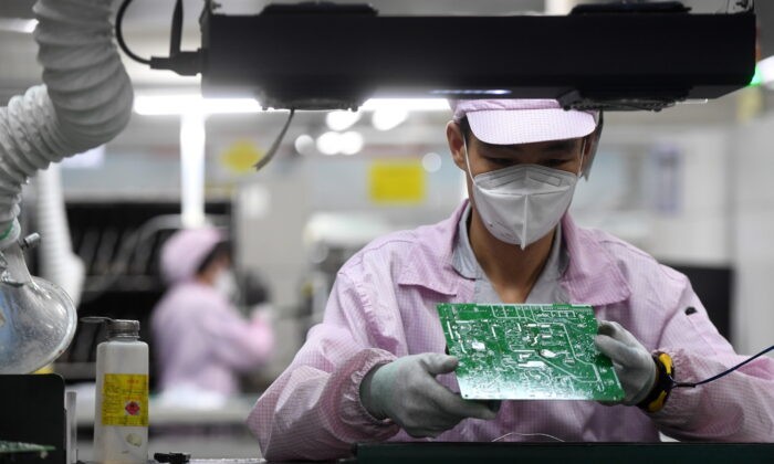 Сотрудник осматривает печатную плату на производственной линии контроллеров на заводе Gree после вспышки COVID-19 в Ухане, провинция Хубэй, Китай, 16 августа 2021 г. CD via Reuters | Epoch Times Россия