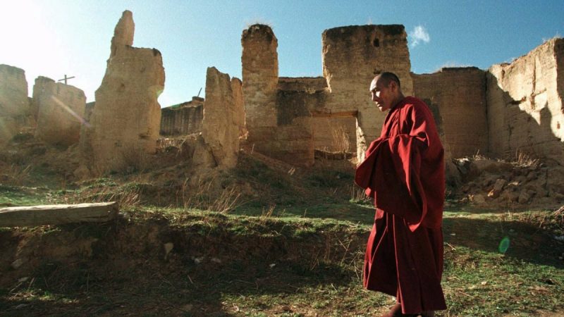 Тибетский монах идёт мимо руин монастыря Гэдань Сунцзаньлин в Шангри-Ла, китайская провинция Юньнань, 23 апреля 1998 года. Большая часть 300-летнего монастыря была разрушена радикальными коммунистами во время культурной революции в Китае. (Greg Baker/AP Photo) | Epoch Times Россия