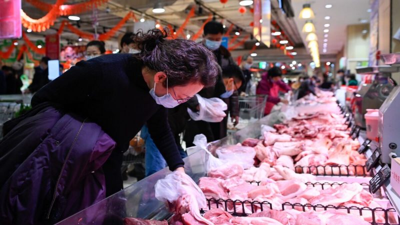 Женщина выбирает свинину в супермаркете, Пекин, 10 февраля 2021 г. (WANG ZHAO/AFP via Getty Images)  | Epoch Times Россия