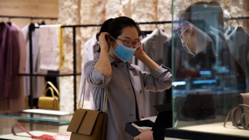 Женщина надевает маску в торговом центре в Ванфуцзине в Пекине, 26 января 2020 г. (Betsy Joles / Getty Images)  | Epoch Times Россия