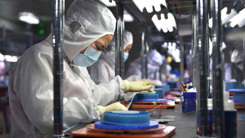 Рабочие производят клейкую ленту для гибких печатных плат на заводе в Яньчэне, провинция Цзянсу, Китай, 15 сентября 2021 года. (STR/AFP via Getty Images)
 | Epoch Times Россия