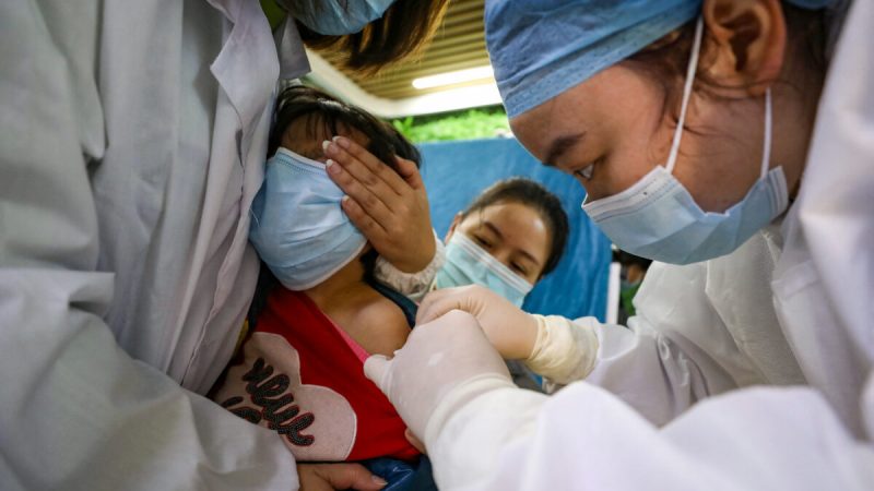 Ребёнок получает вакцину от COVID-19 в Ухане, провинция Хубэй, Китай, 12 ноября 2021 г. (STR/AFP via Getty Images)
 | Epoch Times Россия