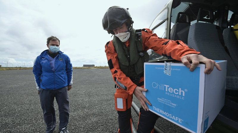 Доктор Алекс Мишель принимает вакцины COVID-19 от члена экипажа ирландского авиационного корпуса, когда военные помогают проводить вакцинацию на отдалённых островах в Инишбофине, Ирландия, 18 мая 2021 года. (Charles McQuillan/Getty Images) | Epoch Times Россия