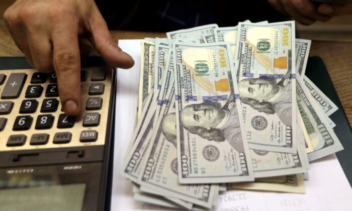 Сотрудник считает долларовые купюры на обменном пункте в центре Каира, Египет, 20 марта 2019 г. (Mohamed Abd El Ghany/Reuters) | Epoch Times Россия