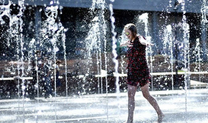 A young woman cools herself while walking across fountains in central Moscow, on May 21, 2014. The temperatures in the Russian capital reached today 28 C (82 F). AFP PHOTO / KIRILL KUDRYAVTSEV        (Photo credit should read KIRILL KUDRYAVTSEV/AFP/Getty Images) | Epoch Times Россия
