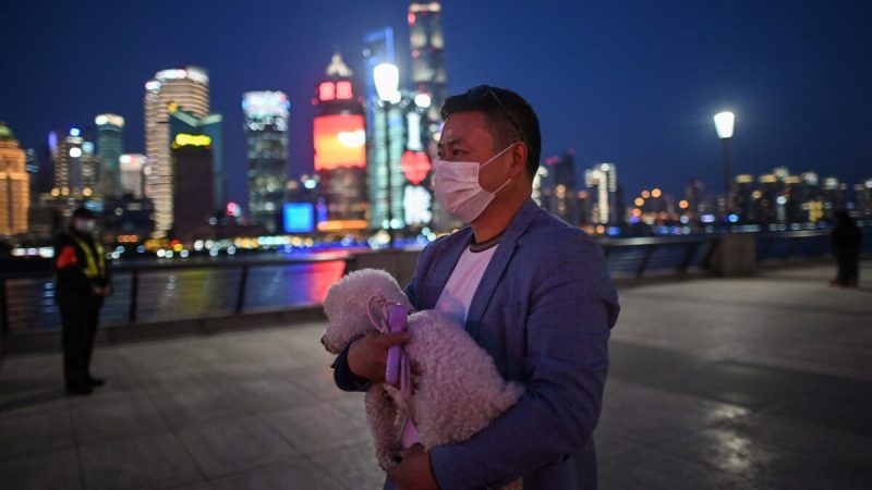 Мужчина с собакой на набережной реки Хуанпу в Шанхае, Китай, 20 марта 2020 г. (Hector Retamal/AFP via Getty Images)  | Epoch Times Россия