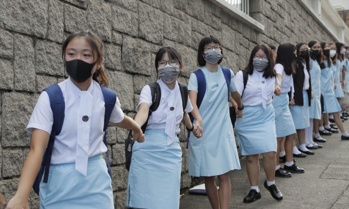 Учащиеся образовали живую цепочку возле школы Maryknoll Convent в Гонконге 6 сентября 2019 года, когда в городе прошли массовые протесты в поддержку демократии. AP Photo / Kin Cheung | Epoch Times Россия