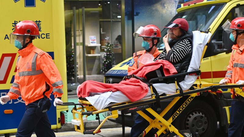 Спасатели несут пострадавшего в машину скорой помощи после пожара во Всемирном торговом центре в Гонконге, 15 декабря 2021 года. (Sung Pi-lung/The Epoch Times)
 | Epoch Times Россия