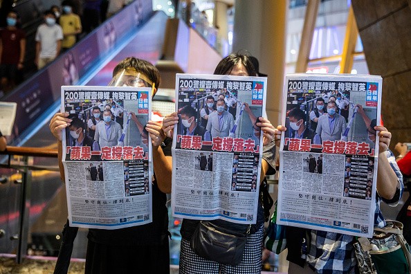 Жители Гонконга спешат купить про-демократическую газету Apple Daily в знак поддержки её владельца, которого накануне арестовали, когда полиция совершала облаву на граждан, критикующих Китай. (Photo: ISAAC LAWRENCE/AFP via Getty Images)