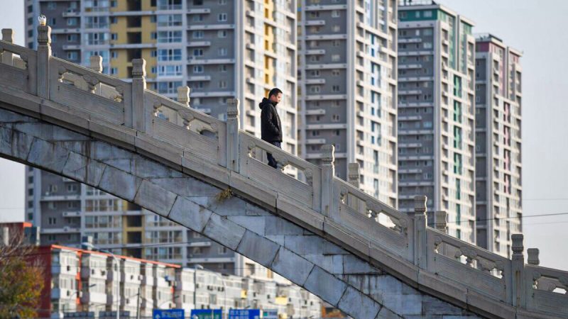 Мужчина переходит мост возле жилого комплекса в Пекине 1 декабря 2020 года. (Greg Baker/AFP via Getty Images)  | Epoch Times Россия