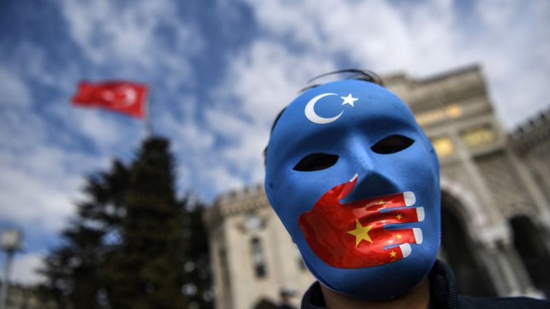 Демонстрант в маске, раскрашенной в цвета флага Восточного Туркестана, принимает участие в акции протеста сторонников уйгурского меньшинства 1 апреля 2021 года на площади Бязид в Стамбуле. (Ozan Kose/AFP via Getty Images) | Epoch Times Россия