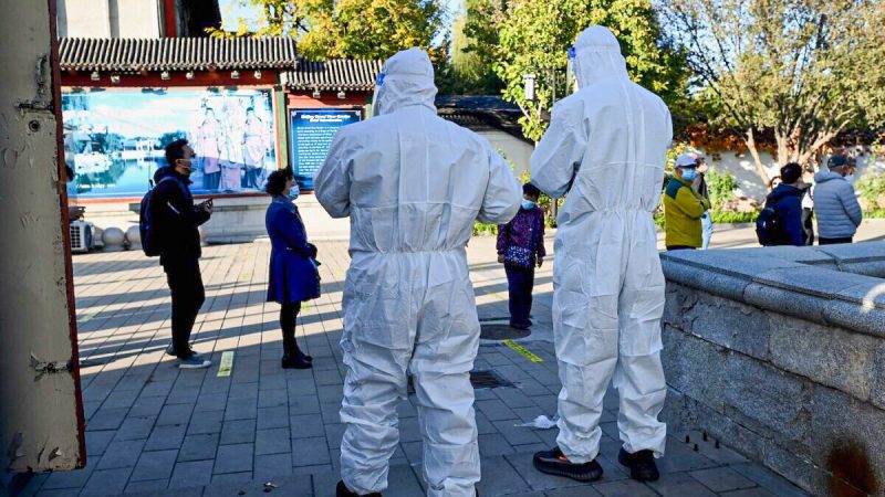 Медицинские работники наблюдают за людьми, стоящими в очереди на сдачу мазков на COVID-19 на станции сбора нуклеиновых кислот в Пекине 26 октября 2021 г. Фото: Noel Celis/AFP via Getty Images
 | Epoch Times Россия