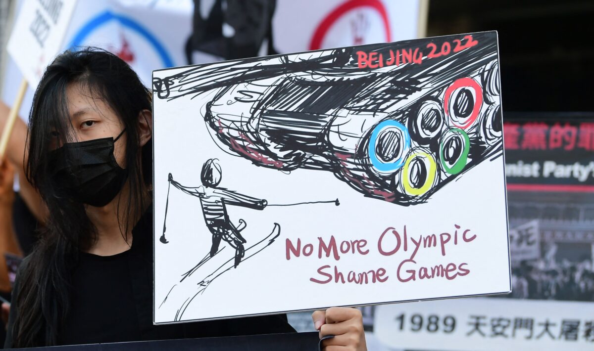 Женщина перед консульством Китая в Лос-Анджелесе, Калифорния, 3 ноября 2021 года, с плакатом, призывающим бойкотировать зимние Олимпийские игры 2022 года в Пекине. Фото: Frederic J. Brown/AFP via Getty Images