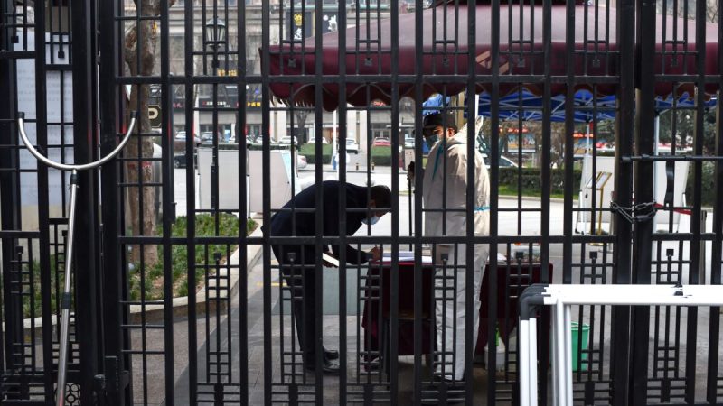 Охранник проверяет информацию о мужчине перед входом в жилой район, который находится на карантине после вспышки COVID-19 в Сиане, 23 декабря 2021 года. Фото: STR/AFP via Getty Images
 | Epoch Times Россия