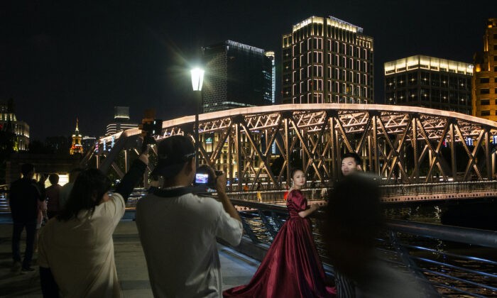 Пара позирует для свадебной фотографии на набережной Бунд 10 сентября 2021 года в Шанхае, Китай. Фото: Hu Chengwei/Getty Images | Epoch Times Россия