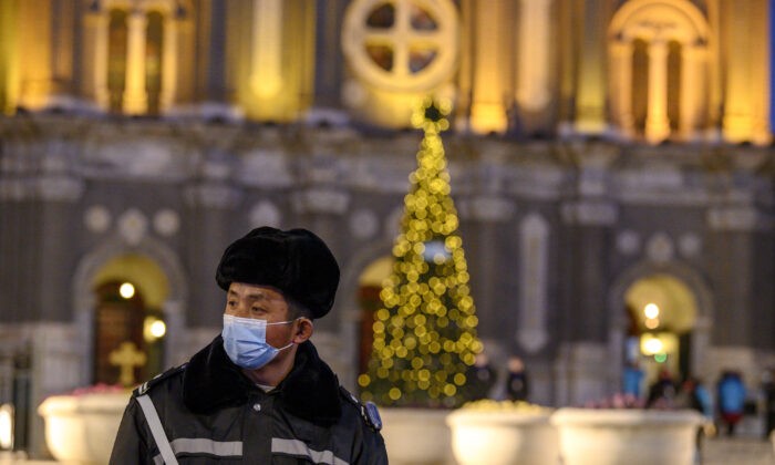 Охранник в маске на страже церкви Святого Иосифа во время мессы в канун Рождества в Пекине 24 декабря 2020 г. (Noel Cells/AFP via Getty Images) | Epoch Times Россия