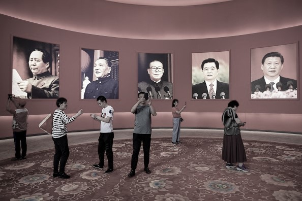 Группа людей фотографируется перед портретами китайских лидеров (слева направо) Мао Цзэдуна, Дэн Сяопина, Цзян Цзэминя, Ху Цзиньтао и Си Цзиньпина на выставке, посвященной достижениям страны за последние 70 лет, в преддверии 70-летия основания коммунистического Китая, в Пекине, 26 сентября 2019 года. (Wang Zhao/AFP via Getty Images)