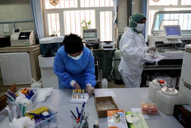 Медики анализируют образцы пациентов с COVID-19. Фото:  SAFIN HAMED/AFP via Getty Images) | Epoch Times Россия