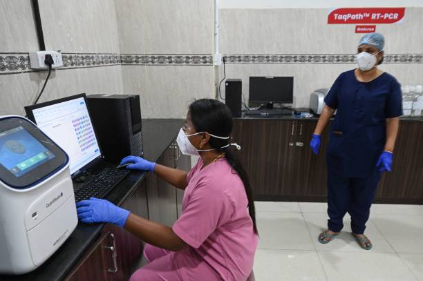 ЮАР. Лаборант (слева) работает в патологической лаборатории, оборудованной для проверки пациентов с коронавирусом Covid-19. Фото:   ARUN SANKAR/AFP via Getty Images) | Epoch Times Россия