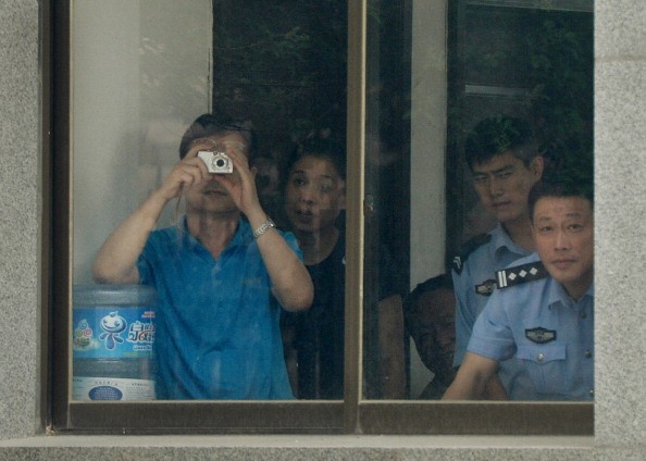 Сотрудники суда и полиция фотографируют в Народном суде промежуточной инстанции, где китайскому политику Бо Силаю было предъявлено обвинение, провинция Шаньдун, 25 июля 2013 г. (Mark Ralston/AFP via Getty Images)