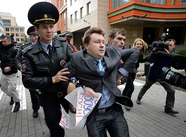 Сотрудники милиции задерживают активиста за права геев во время несанкционированной акции протеста. Фото: ALEXANDER NEMENOV/AFP via Getty Images) | Epoch Times Россия